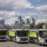 Three HGVs in front of the London skyline
